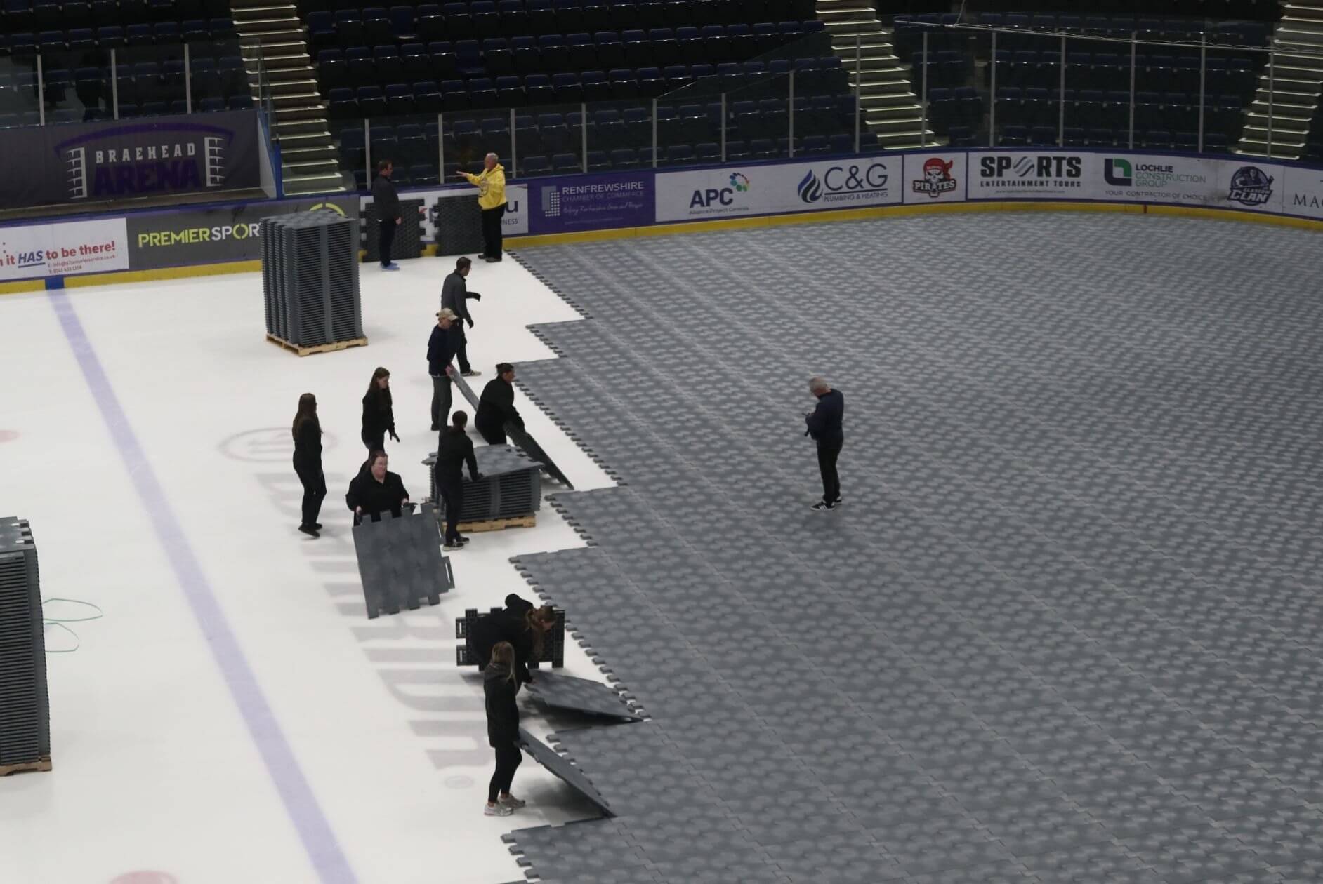 Black EverBase flooring tiles being installed at Braehead Ice Arena by several people
