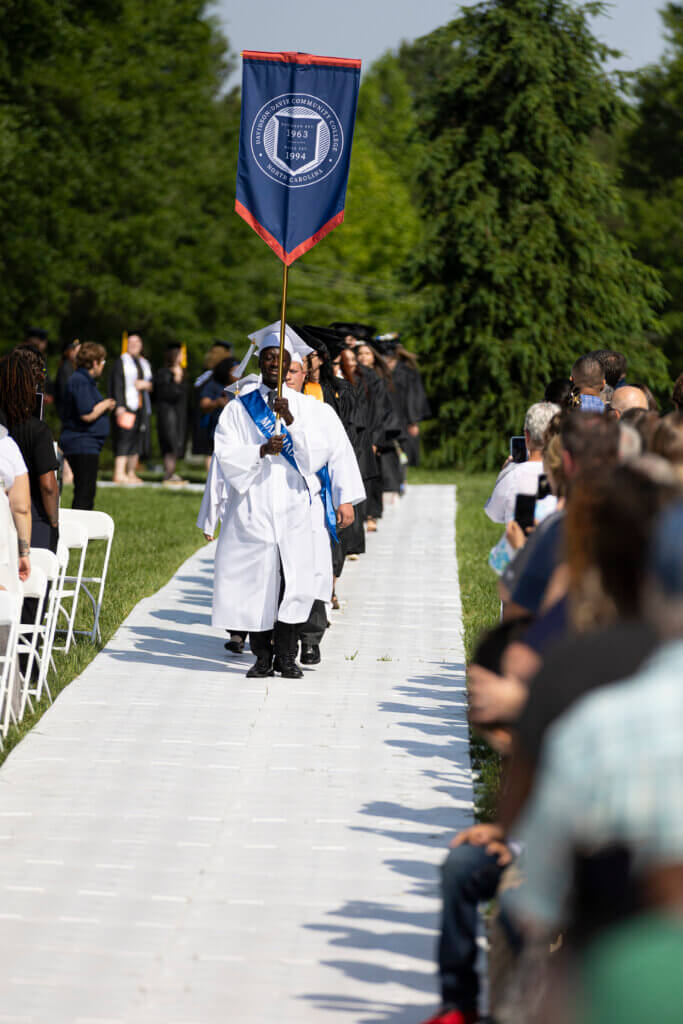 Man walking down the aisle for their graduation ceremony