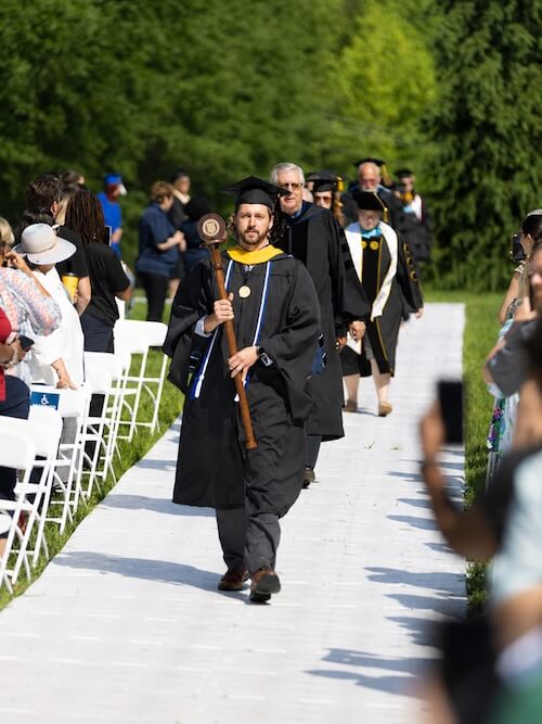 A student walking down the aisle for his commencement